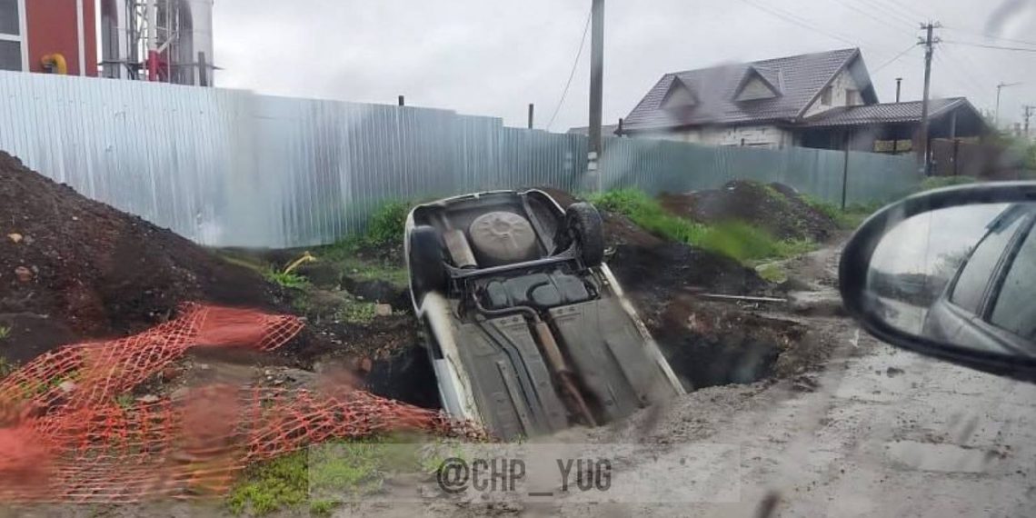 В Краснодаре автомобиль такси наполовину провалился в вырытую яму