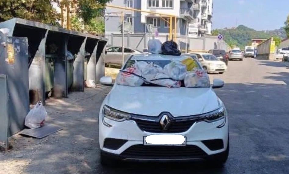 В Сочи припаркованную у мусорных контейнеров машину завалили отходами