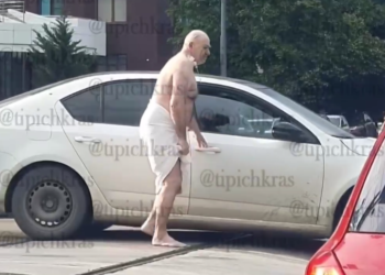 Обмотанный простыней мужчина с катетером в шее ходит по дорогам Краснодара