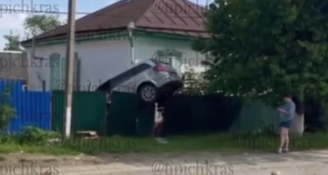 Автомобиль «прилетел» в гости: в поселке на Кубани машина зависла на заборе
