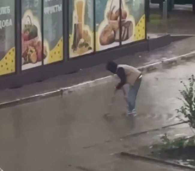 В Краснодаре парень пересёк затопленную дорогу на стремянке и остался сухим