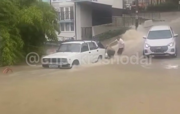 В Сочи поток воды затянул женщину под машину